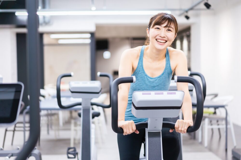 ジムでマシーントレーニングをする若い女性