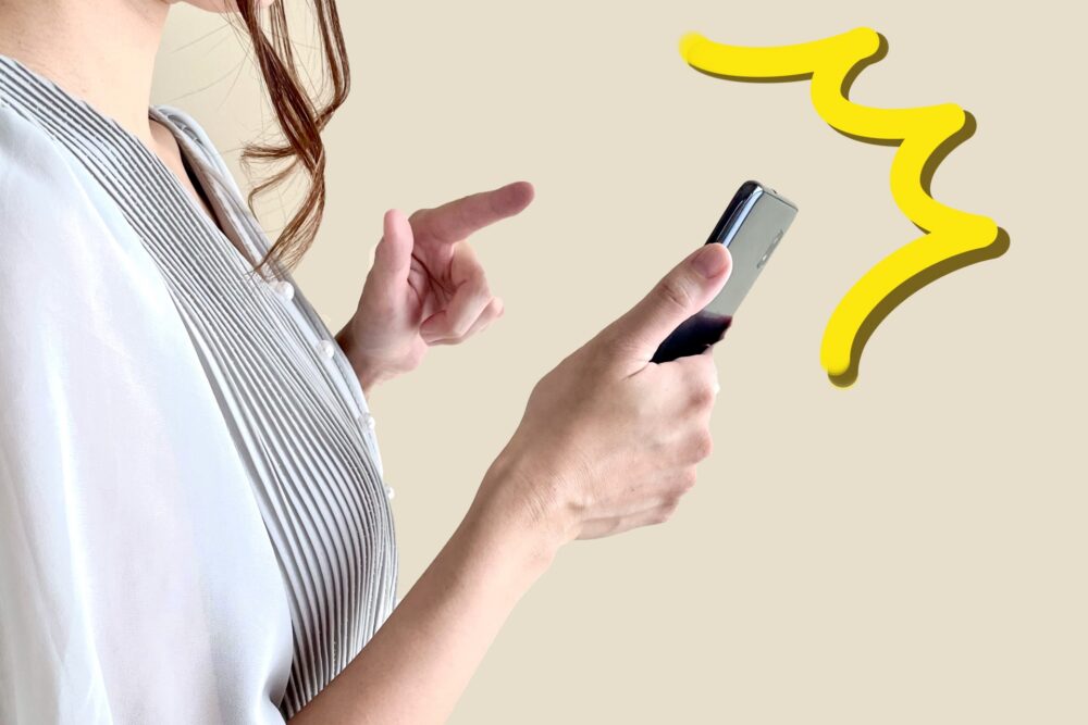 スマホを見て驚く女性